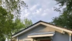 Un petit bâtiment d’un seul étage, doté d’une porte d’entrée et de quelques marches menant à cette porte.