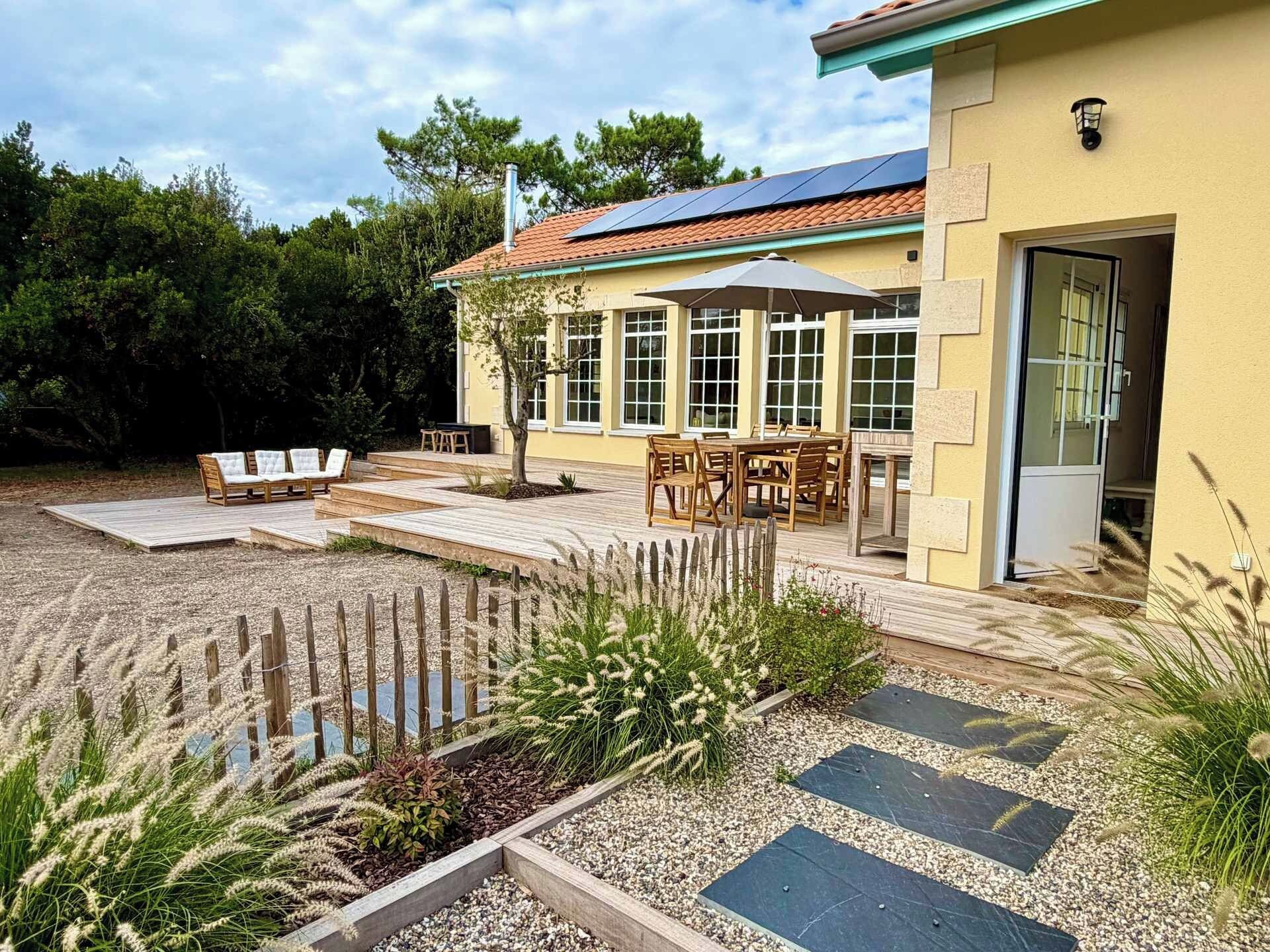 A house with a patio area, outdoor furniture, and a garden.