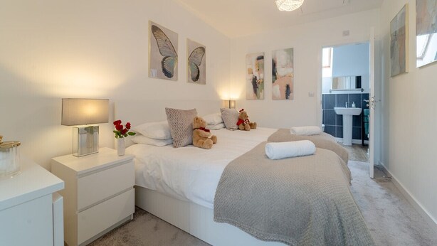 A bedroom with a bed, bedside tables, a lamp, and artwork on the walls.