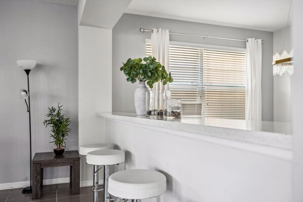 Bright dining area w/ a welcoming table, natural light & an open, airy vibe.