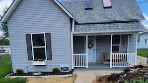 A two-story house with a porch, a number '409' above the door, and a 'Nightingale Rental' sign. - A real charmer built in 1915 , pet friendly , located next to  Mark Twain lake. (Perry)