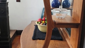 A dining area with a wooden chair, a yellow bowl with fruits, and a clear glass bowl on a wooden table. - A real charmer built in 1915 , pet friendly , located next to  Mark Twain lake. (Perry)
