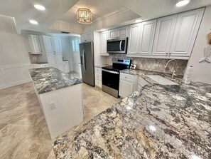 Een koelkast, een oven, een kookplaat, een koffiezetapparaat/waterkoker