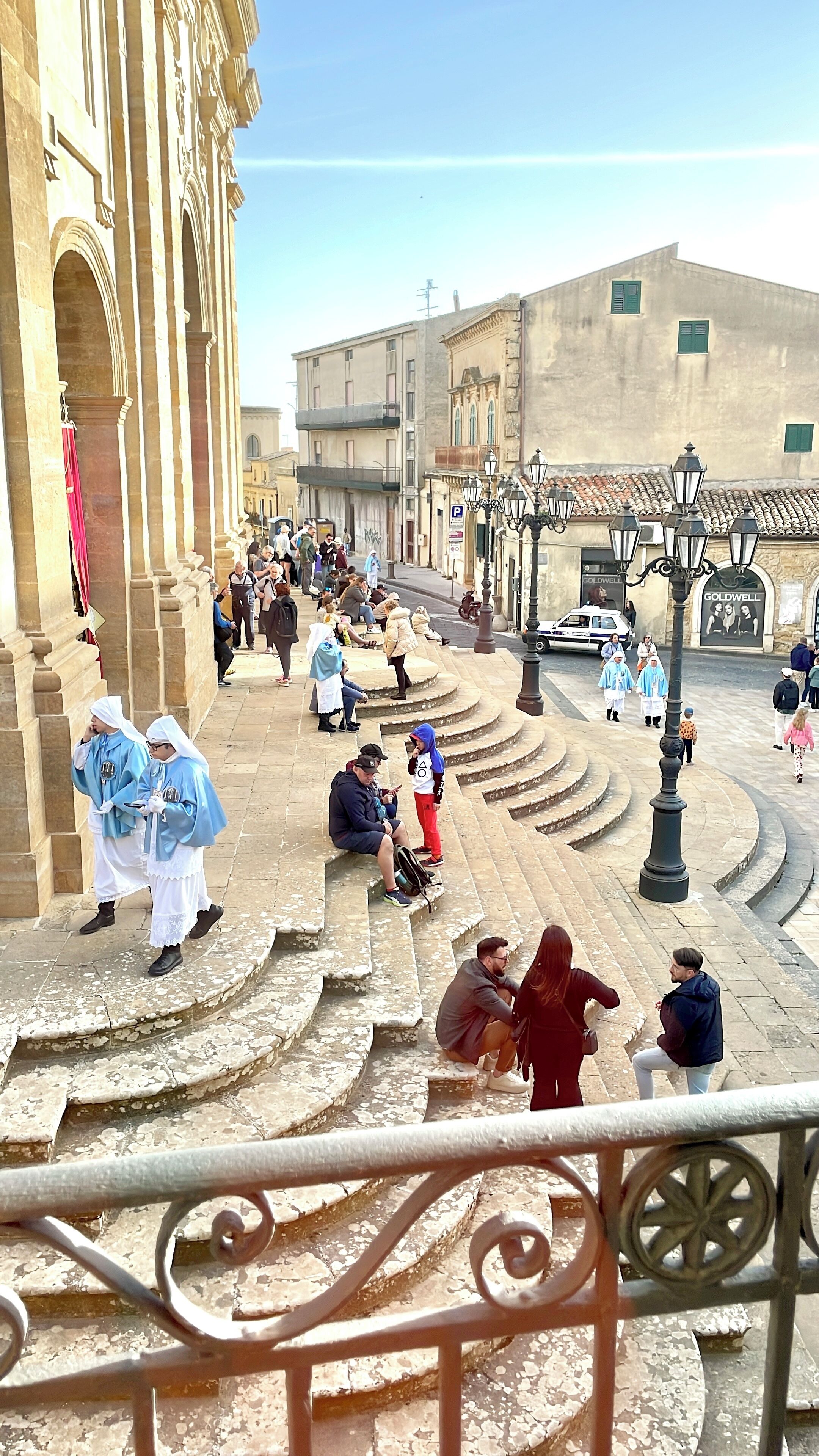 A public square with steps leading up to a building with classical architecture.