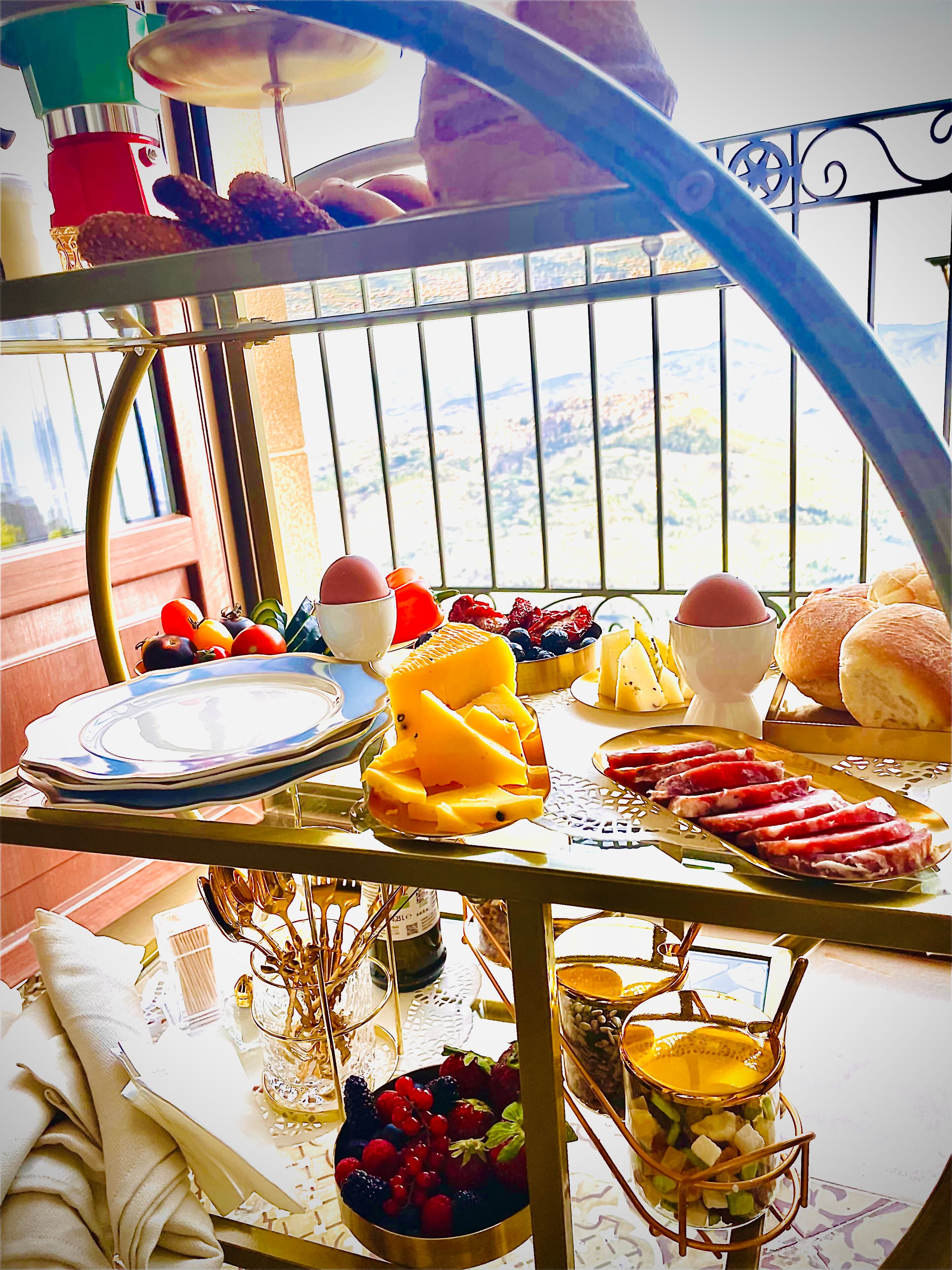 A buffet table with various food items and a view of the cityscape through a window.