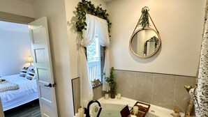 A modern bathroom with a bathtub, a mirror, and a window with curtains. - Happy Valley Spacious Family Townhome.Dog Friendly.Minutes to Blue Mountain (Collingwood)