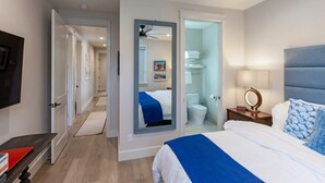Una habitación de hotel con cama, mesita de noche y espejo.