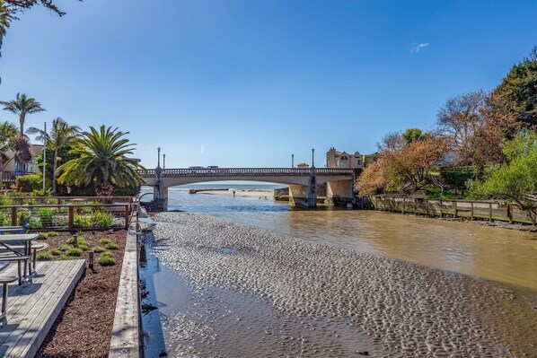 A river with a wooden walkway and a bridge.