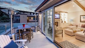 Un espacio exterior moderno con una puerta de vidrio que da a un ambiente interior luminoso.
