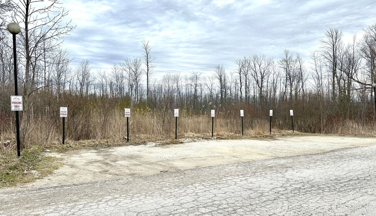 Un’area di parcheggio con diversi cartelli che indicano restrizioni al parcheggio.