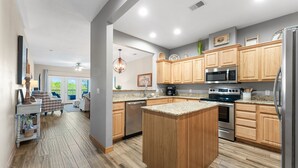Een moderne keuken met houten kasten, roestvrijstalen apparatuur en een centraal eiland.