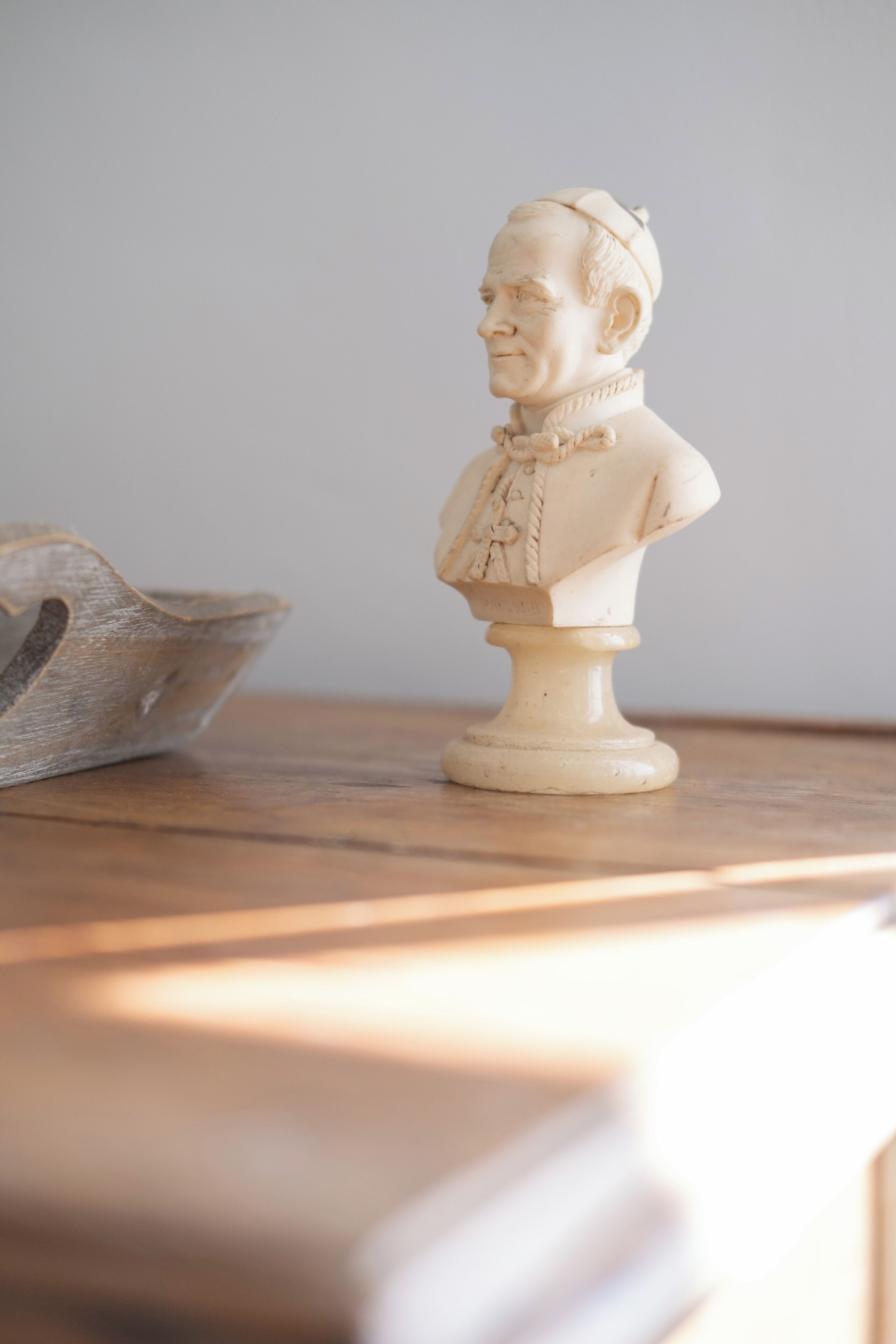 A bust sculpture on a wooden surface.