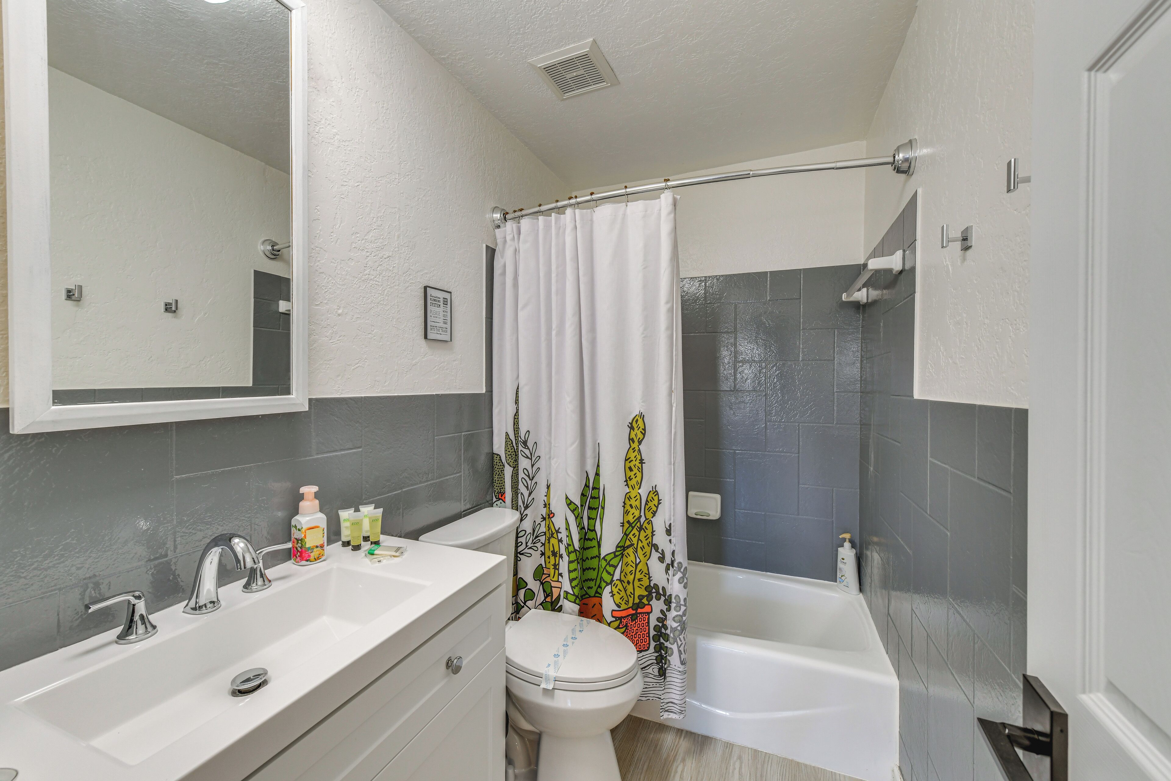 A bathroom with a white sink, two faucets, a toilet, and a bathtub.