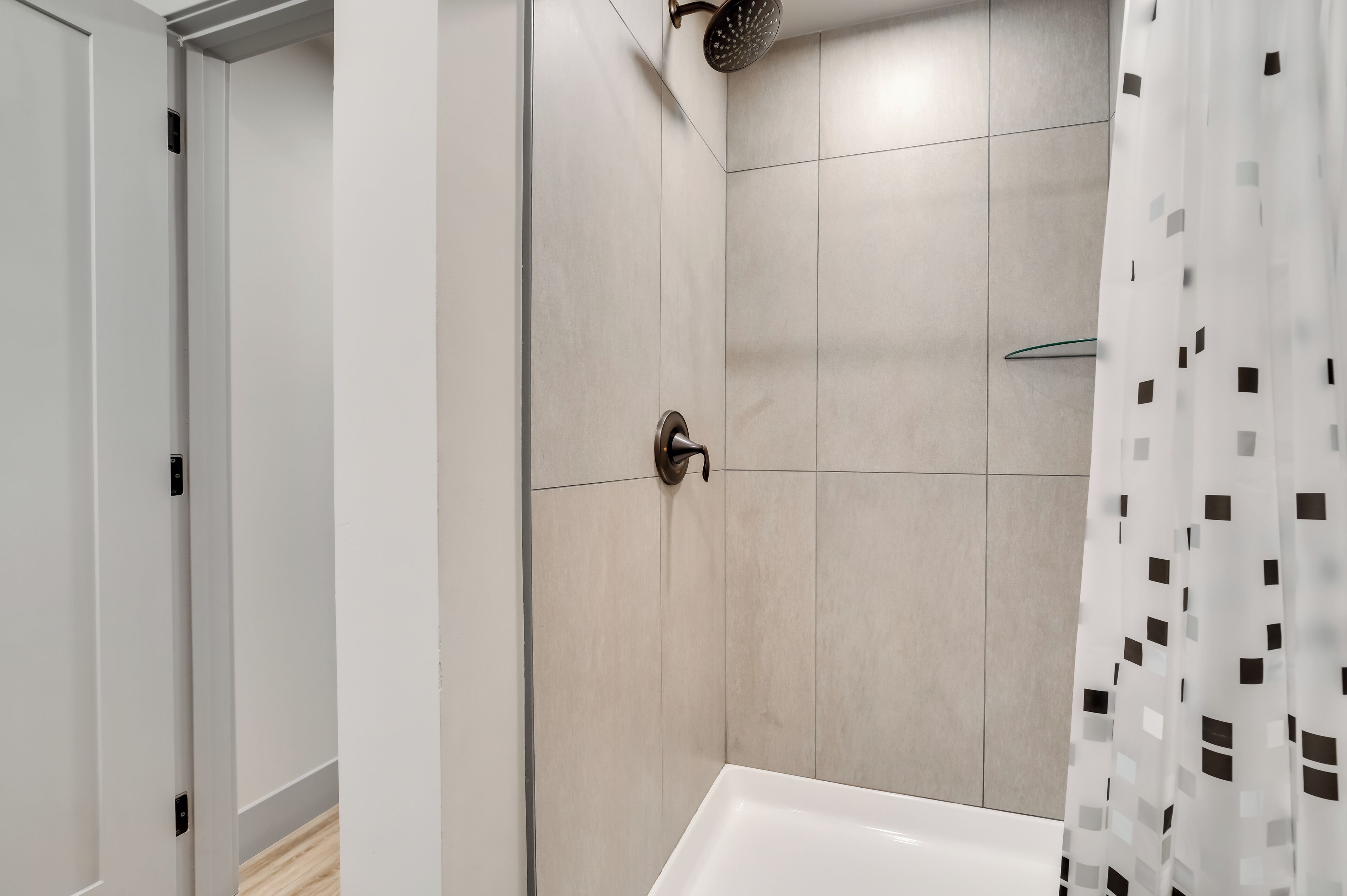 A modern bathroom with a shower, a toilet, and a bathtub.