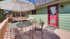 A deck with a round table and chairs, a striped umbrella, and a red door. - Lovely Tobyhanna Getaway, Close to Everything (Tobyhanna)