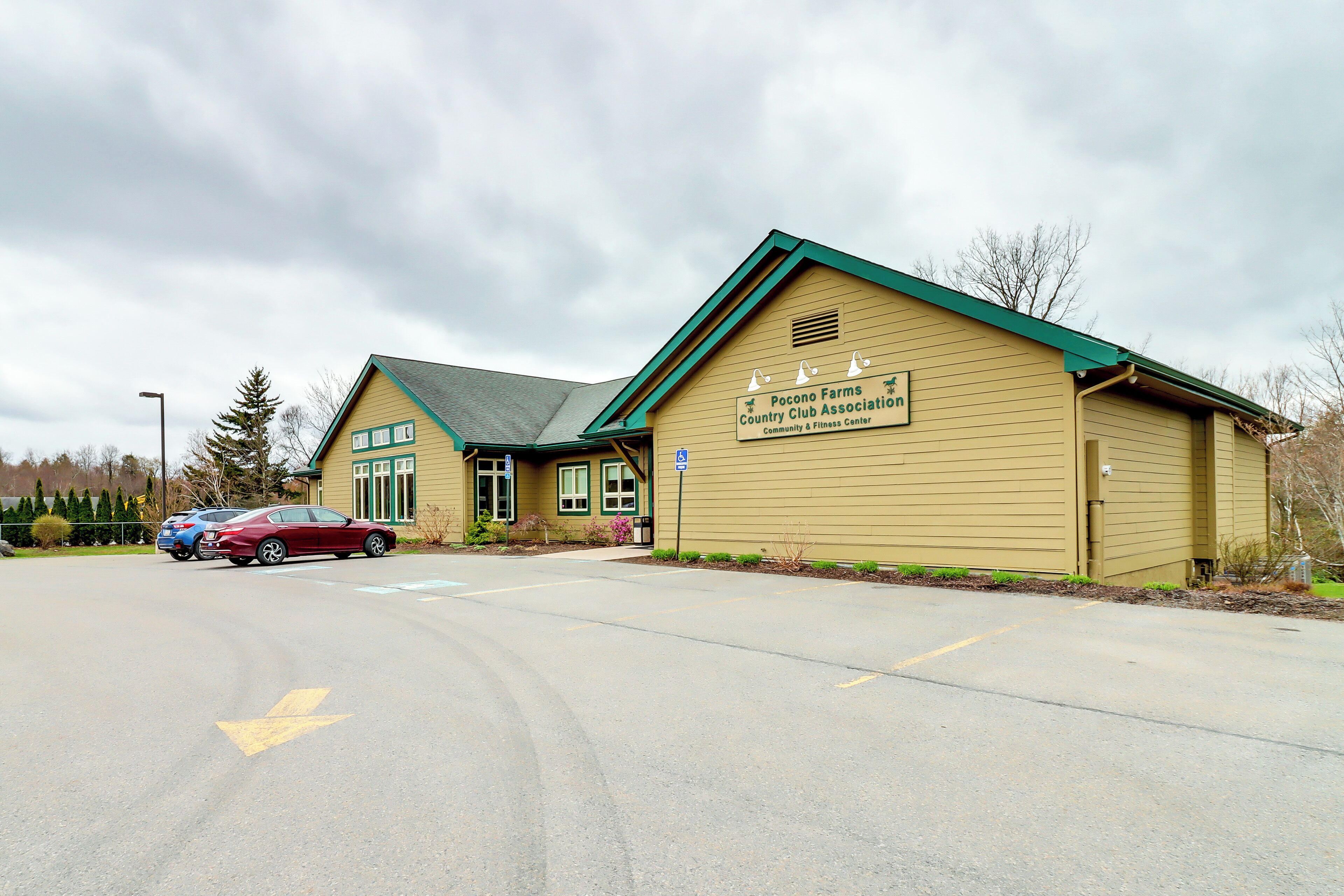 A building with a sign reading "Pocono Farms Country Club Association Community & Fitness Center."