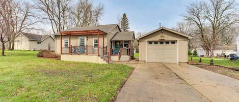 A two-story house with a front porch, garage, and a well-maintained lawn.