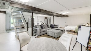 A modern living room with a sectional sofa, a round table, and a whiteboard. - Dry Ridge Farmhouse w/ Hot Tub + Game Room! (Dry Ridge)