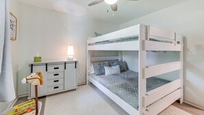 A bunk bed room with a ceiling fan, a bedside table with a lamp, and a small toy horse. - Perry Family Home on 2 Acres w/ Private Pool (Perry)