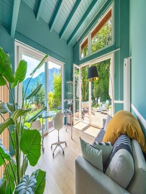 A spacious room with a large window, a sofa, a desk, and a chair. - Villa Artemisia by MyVillaCollection (Lenno)
