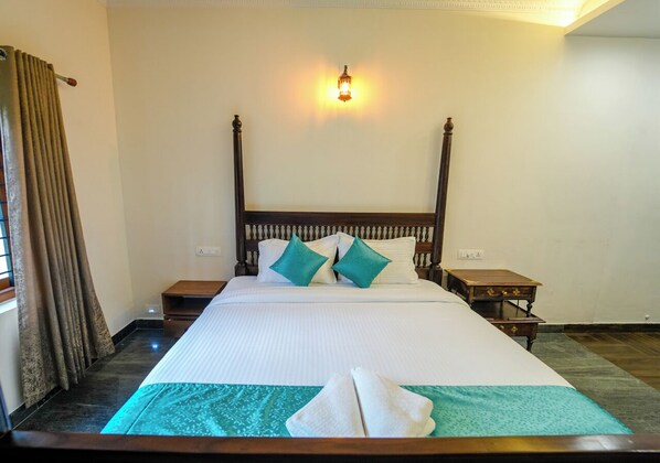 A neatly made bed with a headboard, two pillows, and a bedside table with a lamp.