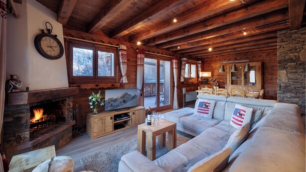 A cozy log cabin interior with a fireplace, wooden ceiling, and a comfortable seating area. - Meribel Les Allues Ski Chalet With Beautiful Views Of The Mountains (Les Allues)