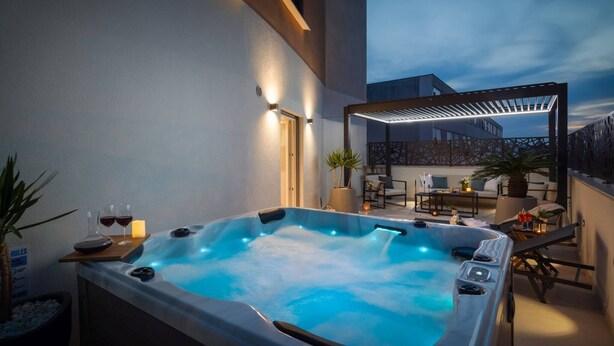 A hot tub with a wooden deck, outdoor seating, and a pergola. - Luxury Apartment Silvery Split with Sauna, Jacuzzi (Split)