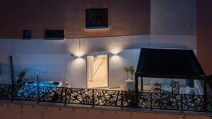 A modern building with a swimming pool, a covered outdoor seating area, and a well-lit entrance. - Luxury Apartment Silvery Split with Sauna, Jacuzzi (Split)