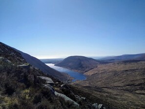 Eine gebirgige Landschaft mit blauem Himmel, einem gewundenen Fluss und felsigem Gelände.