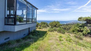 Un bâtiment moderne doté de grandes fenêtres offrant une vue sur un paysage côtier.