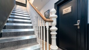 A staircase with a modern design, featuring a combination of metal and wooden elements, leading to a dark door labeled "Number Four". - Modern Studio; Free Laundry & Parking, Fast WIFI (Southampton)