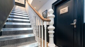 A staircase with a modern design, featuring a metal handrail and carpeted steps. - Stylish Studio; Free Laundry, Long Stay Discounts (Southampton)
