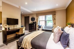 A hotel room with a bed, desk, chair, TV, and a window with curtains. - King Studio • Parking, Free Gym Pass, Fast WiFi (Somerset)