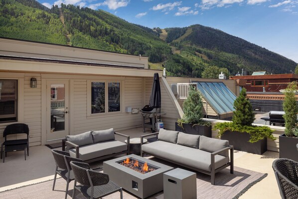 A patio with a fire pit, outdoor furniture, and a view of a mountain. - Luxury Main Street Telluride Penthouse | Steps to Ski, Gondola, Dining & Shops (Telluride)