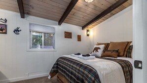 A bedroom with a bed, a window, and wall decorations.