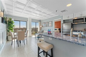 A modern kitchen with a large island, stainless steel appliances, and a view to the outside. - Terrace Suite with Epic Fireworks View (Orlando)