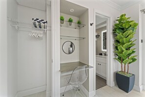 Un baño con ducha, un espejo y repisas con plantas.