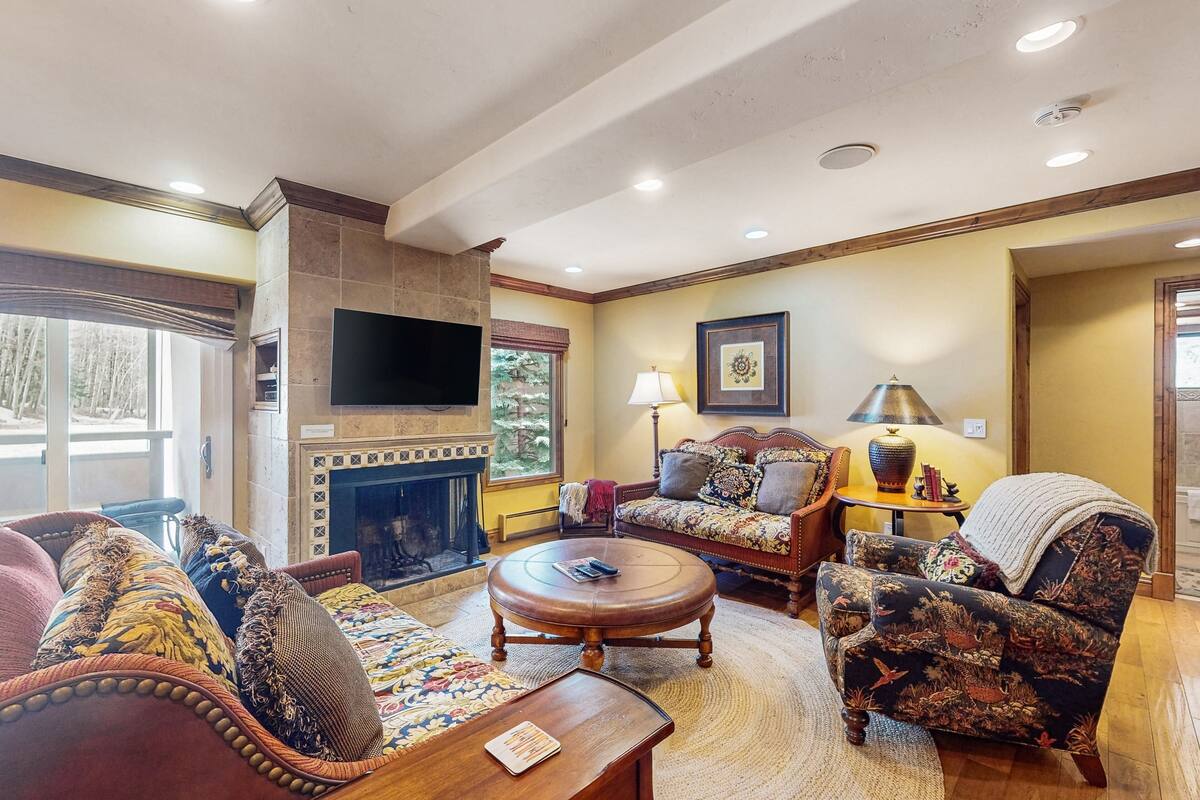 Una sala de estar acogedora con chimenea, asientos cómodos y un televisor de pantalla plana.