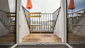 A balcony with a wooden floor, metal railing, and a yellow chair. - 1 bedroom apartment in paris (Paris)
