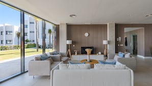 A modern living room with a large window, a flat-screen TV, and a coffee table. - Pure South II 2447 Penthouse (Manilva)