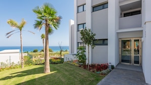 A modern building with a white facade, a balcony, and a view of the sea. - Pure South II 2447 Penthouse (Manilva)