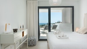 A modern bedroom with a bed, bedside table, and a view of the outdoors. - Pure South II 2447 Penthouse (Manilva)