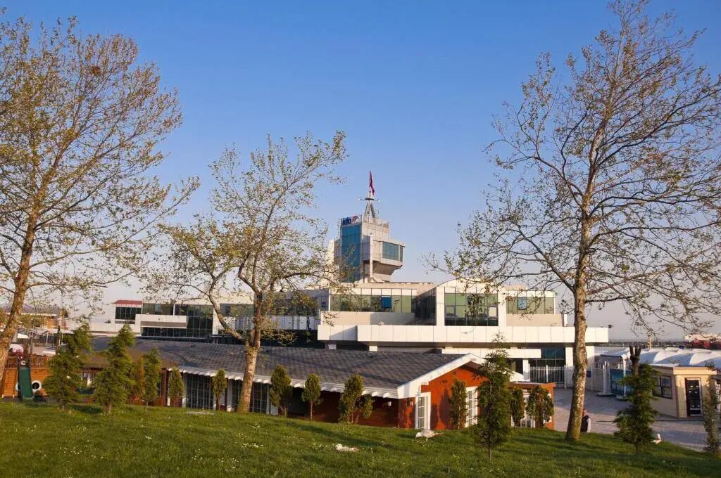 A modern building with a prominent tower and a flat-roofed structure.