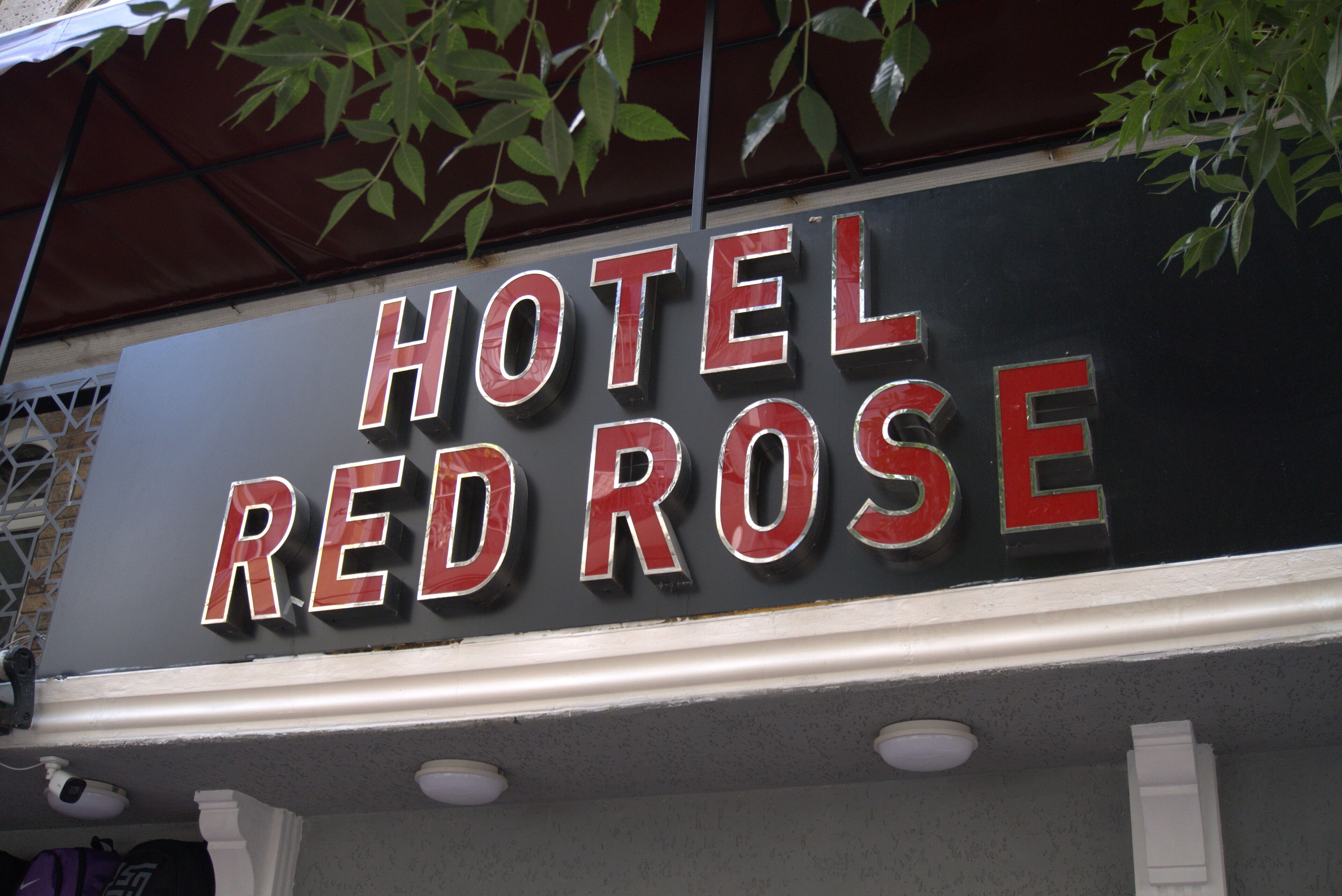 Señalización para “HOTEL RED ROSE” con diseño moderno y letras metálicas.