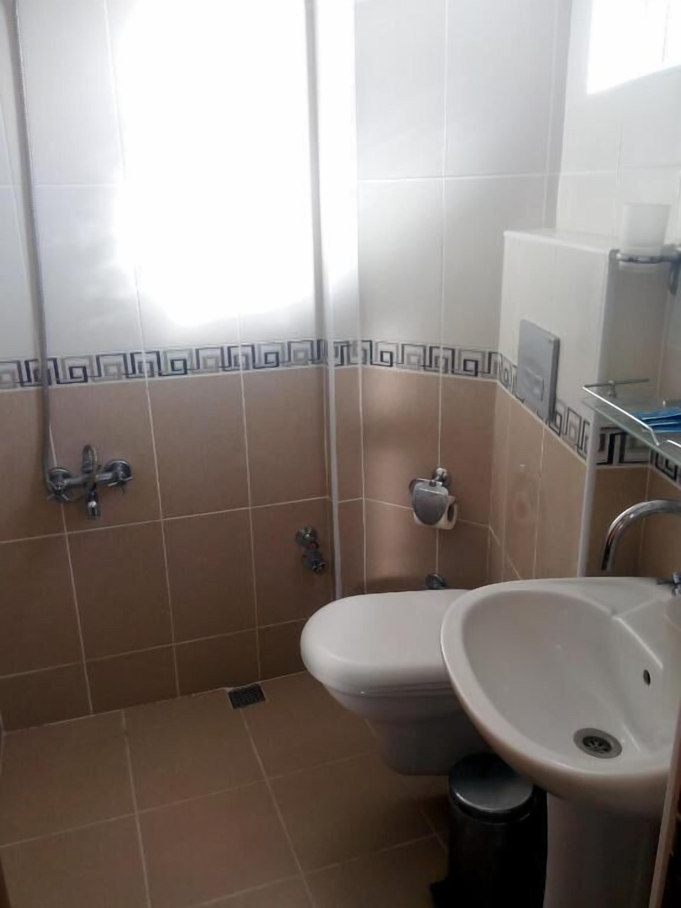 Ein kleines Badezimmer mit Toilette, Waschbecken und Dusche.