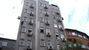 Un edificio de varios pisos con un letrero que dice 'Hotel Red Rose'.