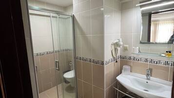 Habitación triple estándar, vistas al mar | Baño | Ducha, artículos de higiene personal gratuitos y secador de pelo