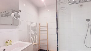 A modern bathroom with a white sink, a glass shower enclosure, and a wooden ladder. - N&J - POP ART - Central - Balcony (Niza)