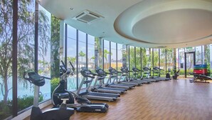 Een fitnessruimte met loopbanden, hometrainers en een elliptische machine.