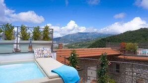 A rooftop pool area with a lounge chair and a blue towel, overlooking a mountainous landscape. - Villa Grazielluccia with Sea View and Pool (Priora)